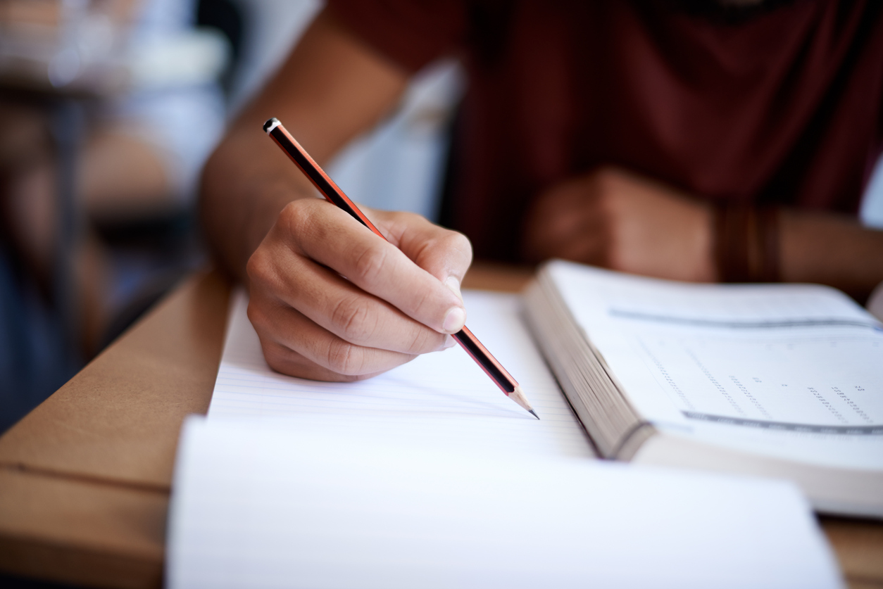 Estudante escrevendo em caderno